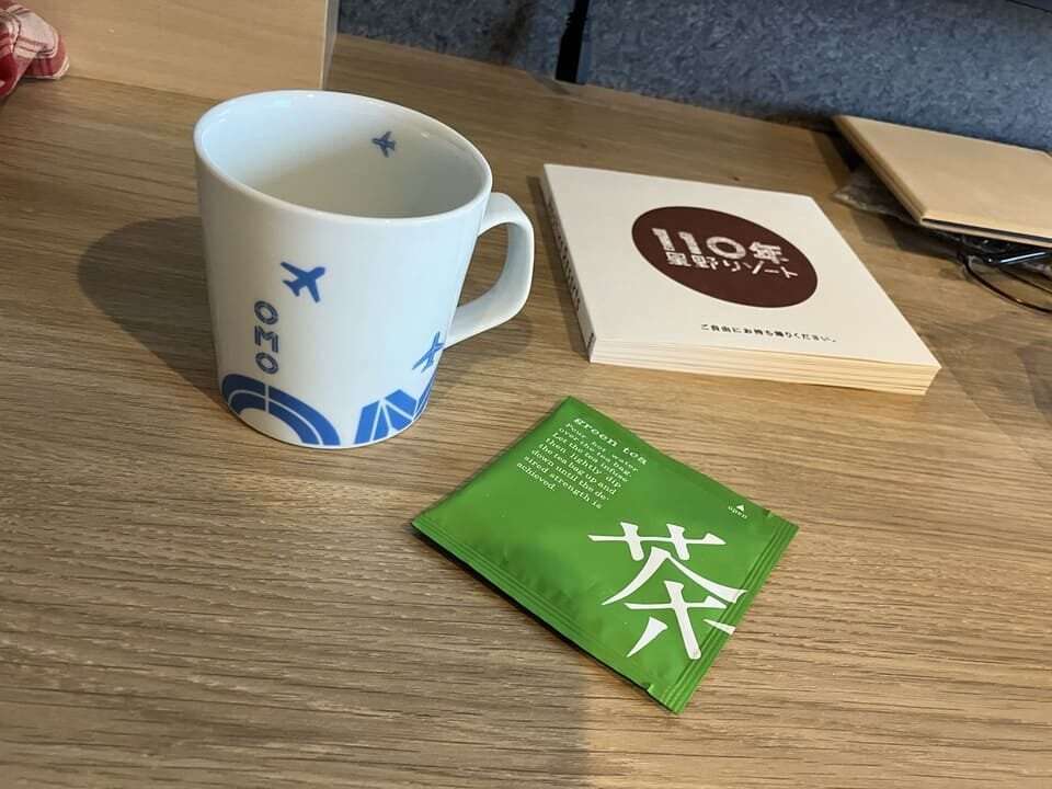 マグカップと緑茶ティーバックとハンドブック