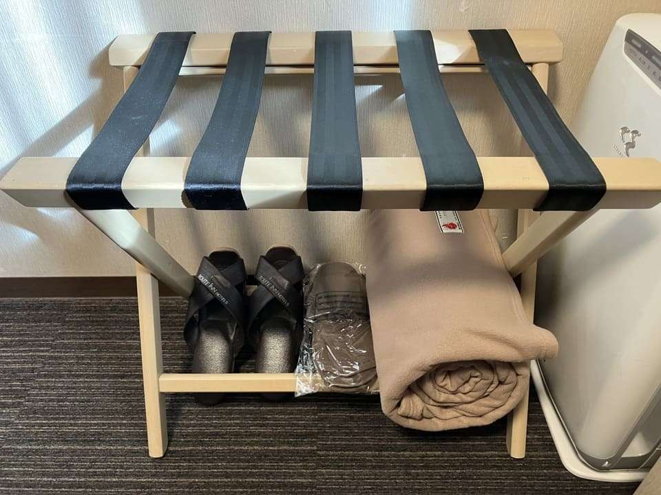 バゲッジラックの下のスリッパと毛布